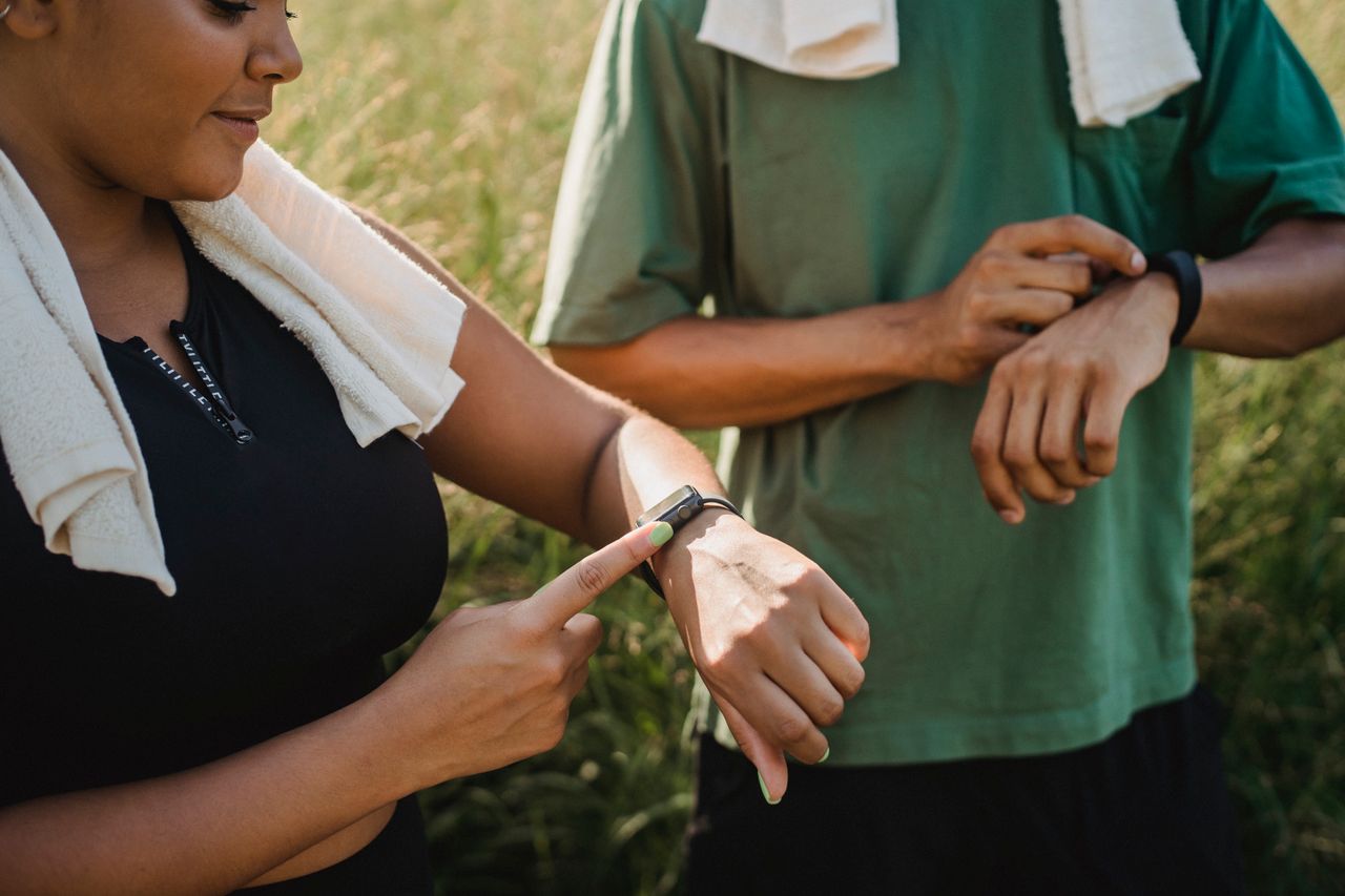 Crafting Captivating Headlines: Your awesome post title goes here Two people checking their fitness watches while taking a break from a workout outside.